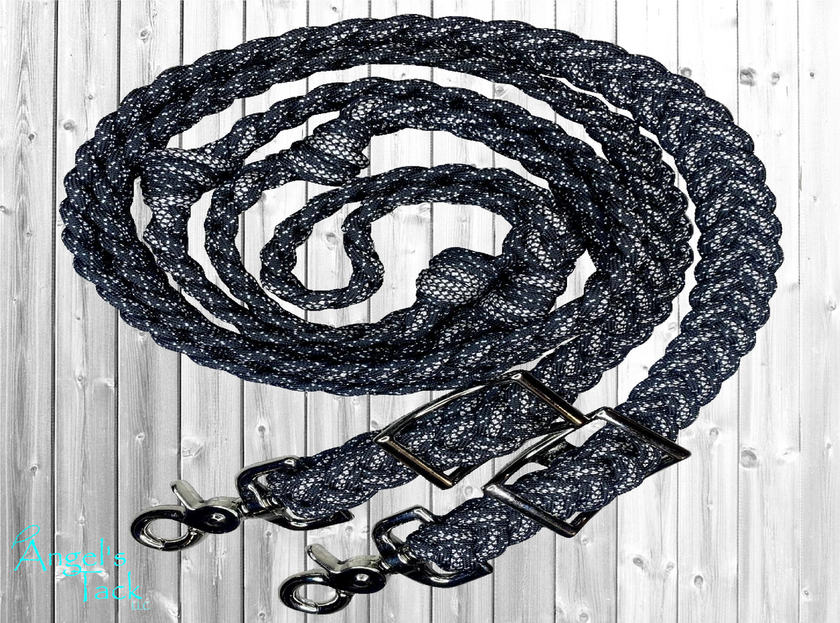 Black diamond and sparkle patterned braided paracord barrel reins by Angel's Tack LLC. Shown coiled on a grey wooden background.