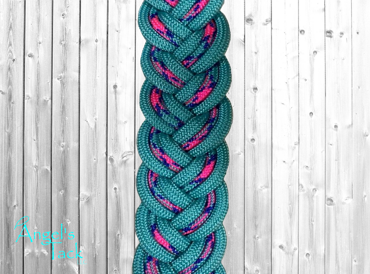 A close up of turquoise and hot pink patterned braided paracord barrel reins by Angel's Tack LLC. Shown on a grey wood background.