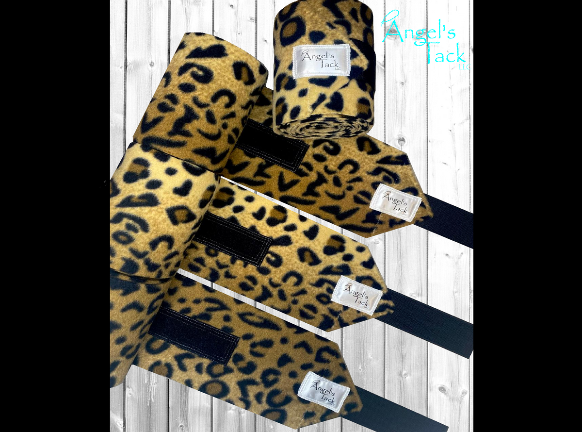 Leopard print horse polo wraps by Angel's Tack LLC. Shown unrolled on a grey wooden background.
