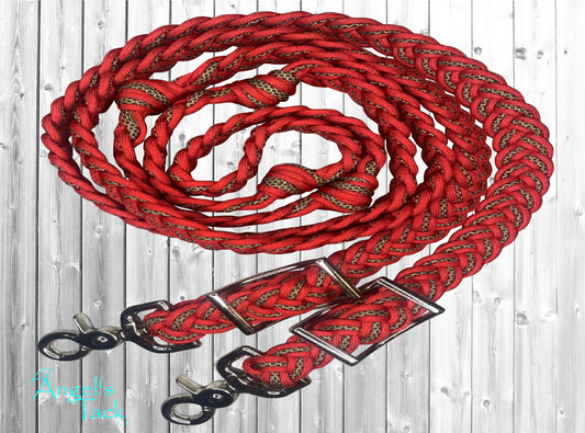 Red and leopard print braided paracord barrel reins by Angel's Tack LLC. Shown coiled on a grey wooden background.