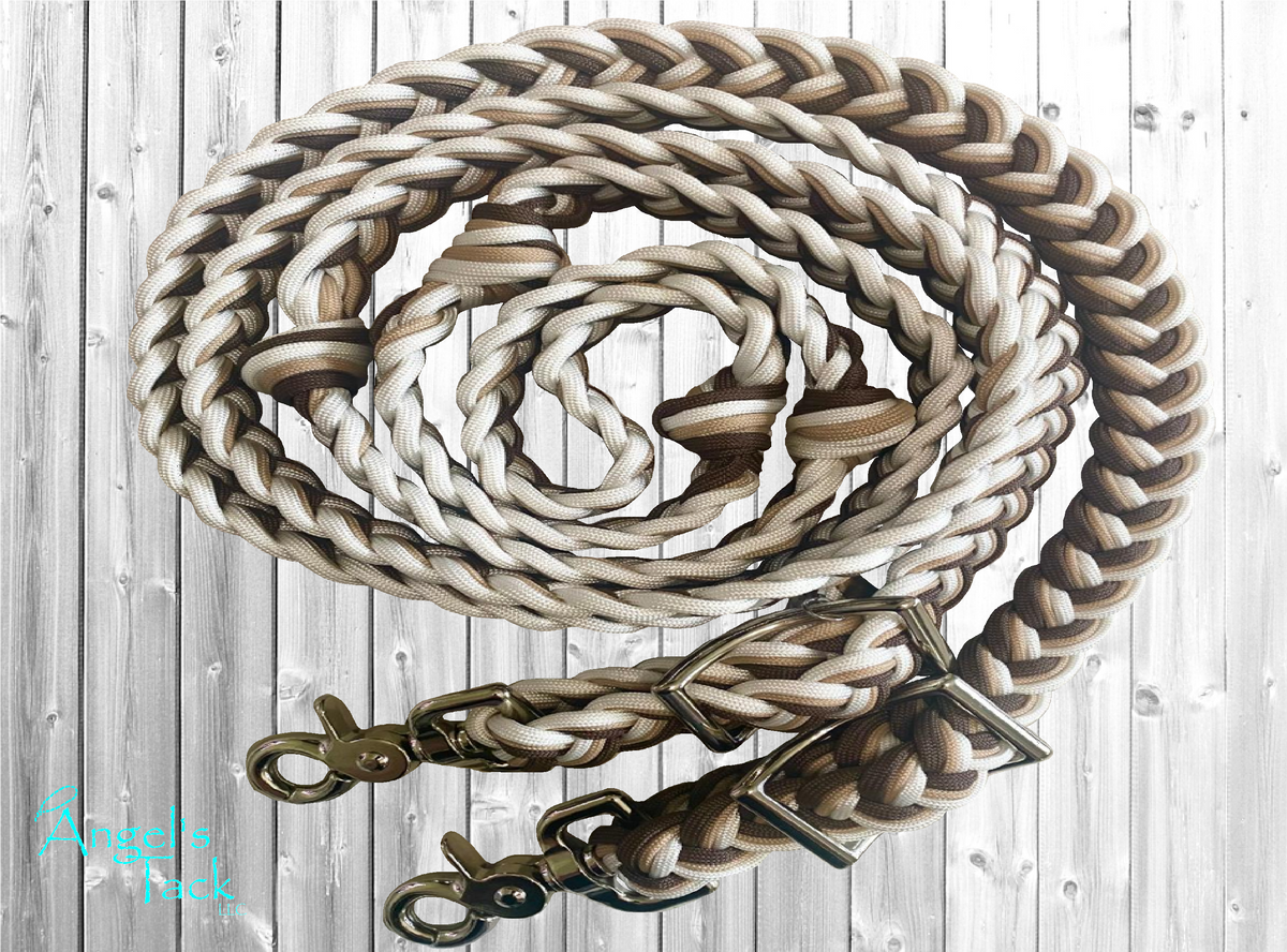 Brown, tan, and white braided paracord barrel reins by Angel's Tack LLC. Shown coiled on a light grey wooden background.