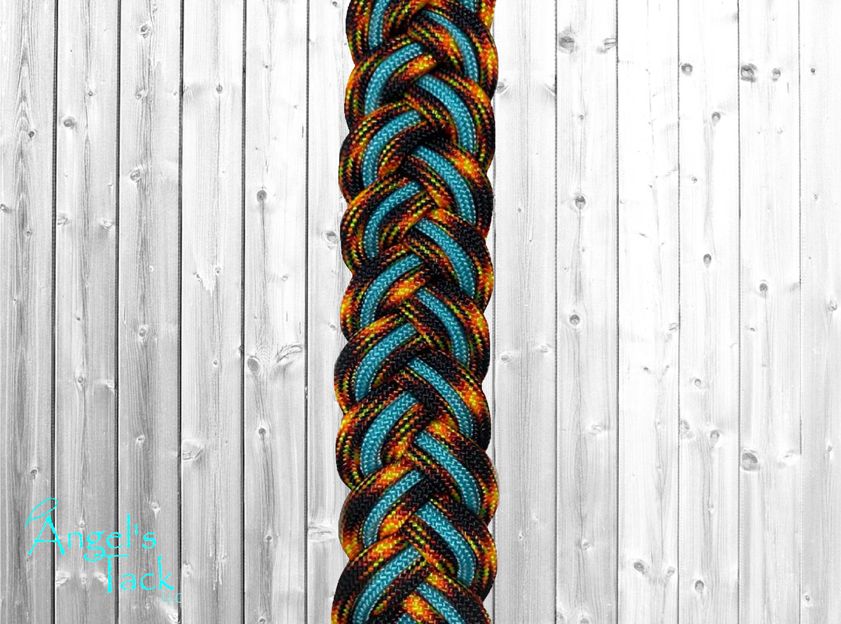 A close up of turquoise and orange flame patterned braided paracord barrel reins by Angel's Tack LLC. Shown on a grey wooden background.